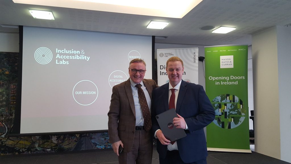 Kyran O'Mahoney and Chris White holding the Digital Accessibility Index report