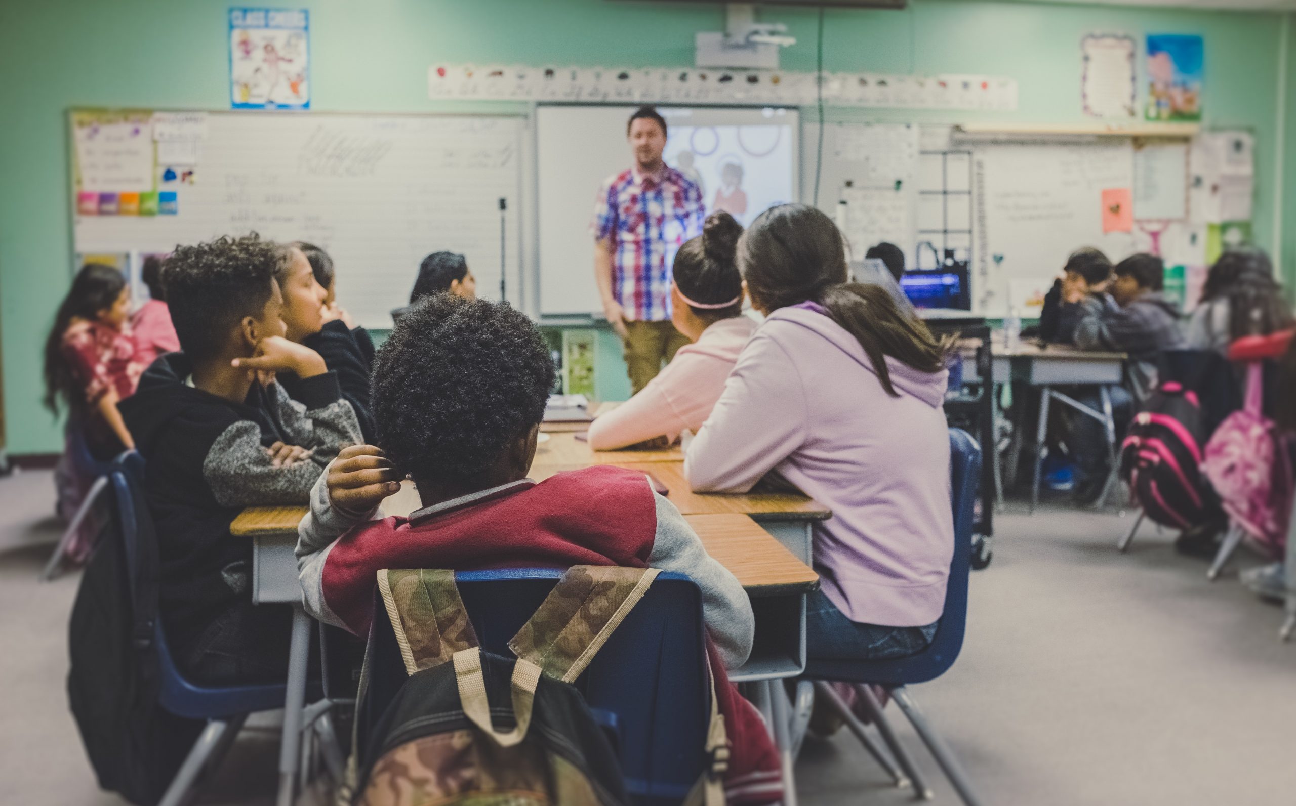 A classroom of students listening to their teacher