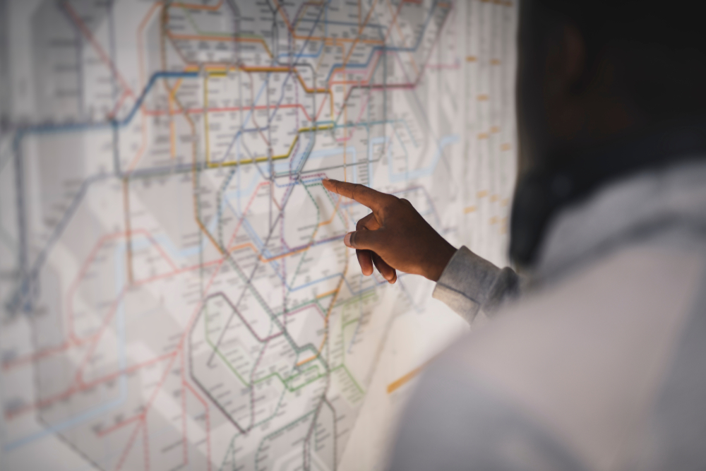 Hand pointing at a map of a railway system