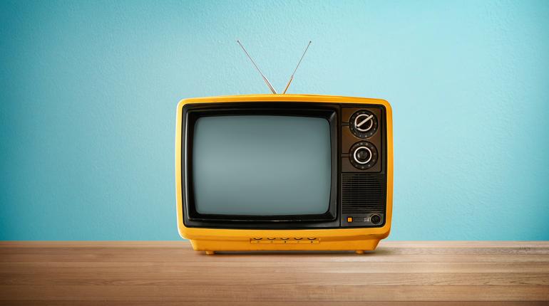 Vintage yellow television on a wooden table