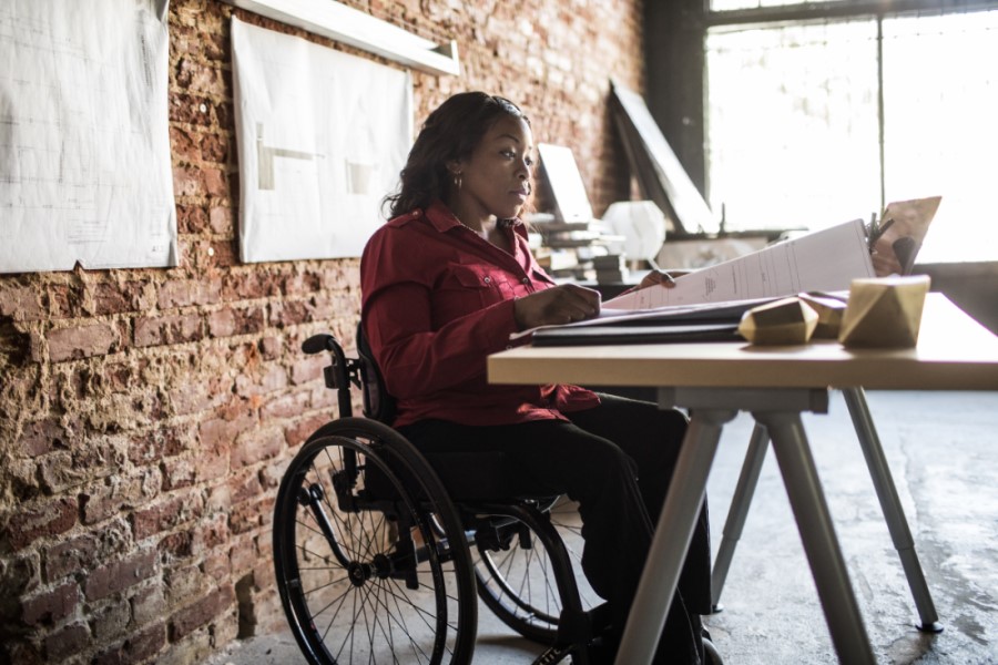 Black woman in a wheelchair looking through documents