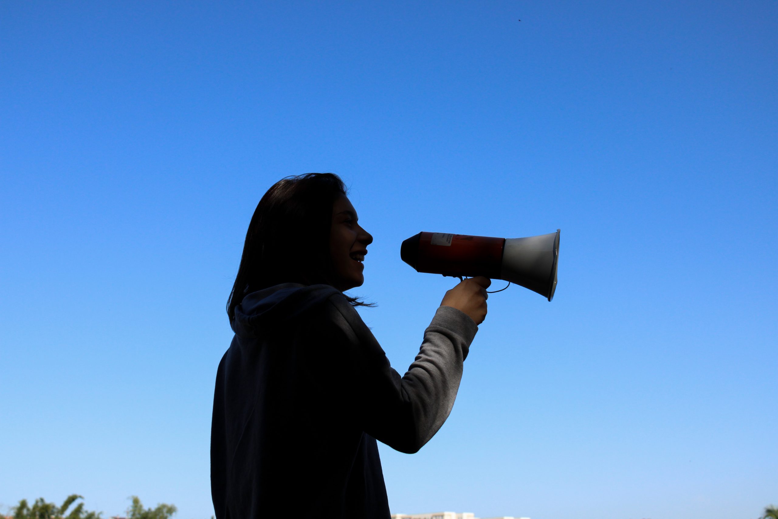 Silhouette of a person holding a megaphone during a protest